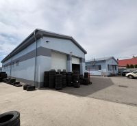 Warehouses and halls in Orechová Potôň with tires and cars in the yard.