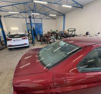 Red car and motorcycles in the workshop Warehouses and halls with a car in the background.