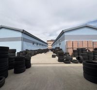 Double rows of tires and construction materials between warehouses and halls in Orechová Potôň.