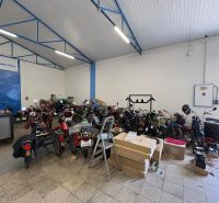 The interior of a workshop with motorcycles and parts on the floor. Warehouses and halls.