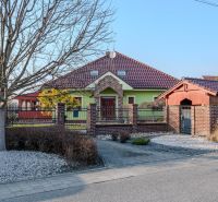 A family house in Dolný Bar with a red roof and green facade.