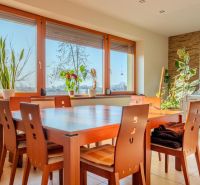 A bright dining room in a family house with a wooden table and plants.