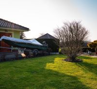 A family house in Dolný Bar with a boat in the garden and a shelter.