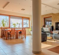 A living room in a family house with large windows and comfortable furniture.