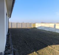 A family house in Michal na Ostrove with a grassy garden and a concrete fence.