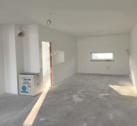A spacious room with a gray floor and white walls in a family house.