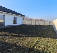 A family house in Michal na Ostrove with a garden and a stone fence at the back.