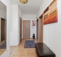 Interior of a family house with a carpet runner, wooden decor, and modern wall art.