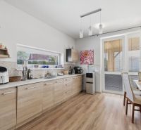 A kitchen in a family house with a wood-patterned floor, a dining table, and decorations.
