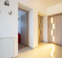 Interior of a family house with a wooden decor floor, central heating, and wall decorations.
