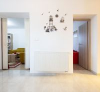 Interior of a family house with white walls, wall decoration, and an open entrance to the living room.
