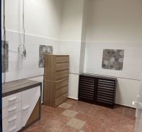 Commercial space with white walls, furniture, and ceramic tiles on the floor.
