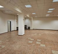Interior of a commercial space with tiled flooring and ceiling lighting.