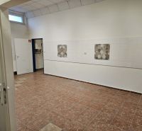 The interior of commercial spaces with tiled floors and white walls with patterned tiles.