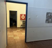 Interior of commercial premises with tiles and tiled floor, open door.