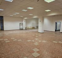 Spacious commercial spaces with a tile-patterned floor and white walls.