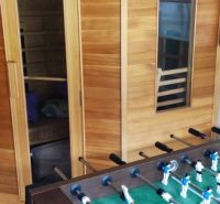 Sauna and table football in a family house with a wooden decor floor.