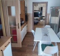 A kitchen in a family house with a wood-patterned floor and modern equipment.