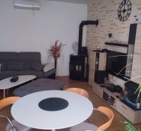 Living room in a family house with a wood-patterned floor, a sofa set, and a table.