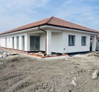 A family house in Michal na Ostrove under construction with a white facade and a hipped roof.