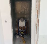 Space for installing a toilet in a family house with unfinished walls and floor.