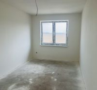 Empty room with gray floor, window, and white walls in a family house.