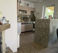 A kitchen in a family house with a brick bar and fireplace, tiled floor.