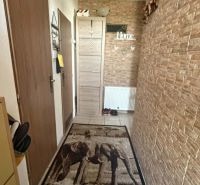 Entrance hallway in a family house with an elephant carpet and stone walls.