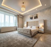 A bedroom with an upholstered bed in a family house, stylish lighting, and a peaceful atmosphere.