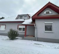 A family house in Dolný Štál with red window frames and a snow-covered roof.