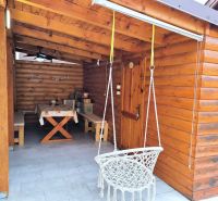 The terrace of a family house in Ohrady with wooden cladding and a swing.