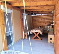 A terrace in a family house in Ohrady with wooden elements and a hammock.