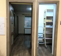 The interior of a family house with a wooden decor floor and open doors.