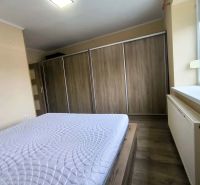 Bedroom in a family house with a sliding wardrobe and a wooden decor floor.