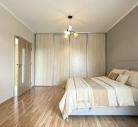 Bedroom in a studio apartment with a bed and a wooden decor floor.
