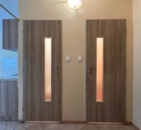 Interior of a one-room apartment with wooden decor doors and tiles.