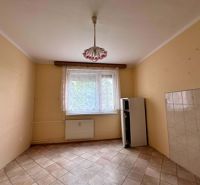 A room with tiles, bright walls, a radiator, and a pendant light.