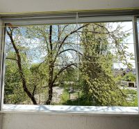A view from the balcony of a one-room apartment in Dunajská Streda overlooking trees and the city.