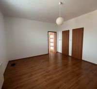 A room in a 3-room apartment with white walls and a floor with a wooden decor.