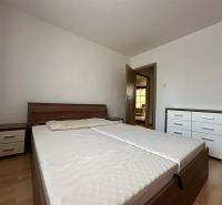 Bedroom with a bed, nightstands, and a dresser in a 3-room apartment, floor with wood decor.
