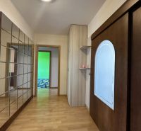 A hallway in a 3-room apartment with a wooden decor floor and built-in wardrobes.