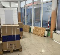 Pallet packaging in commercial premises, light tiles, shop windows with advertising banner.