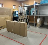 Interior of commercial spaces with shelves, a ladder, and packed boxes for storage.