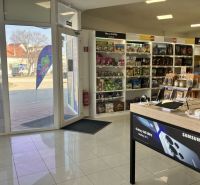 Retail spaces with electronics and toys, wooden decor flooring, light from the exterior.