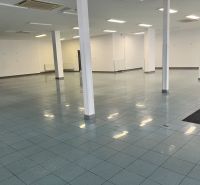Spacious commercial premises with tiles and columns, ideal for various uses.