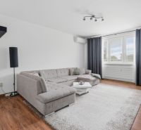 A bright living room with a corner sofa, wood-patterned flooring, 3-room apartment.