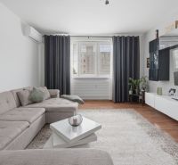Living room in a three-room apartment with a comfortable sofa and a floor with a wooden decor.