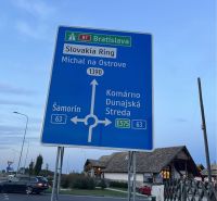 A road sign in Holice shows the direction to Slovakia Ring and cities like Šamorín, Komárno.