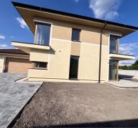 A family house in Dunajská Streda on GARDENTOWN street with a paved parking lot and a garage.