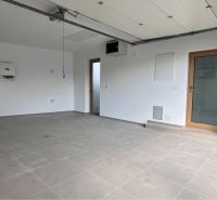 A garage in a family house with a tiled floor and white walls.